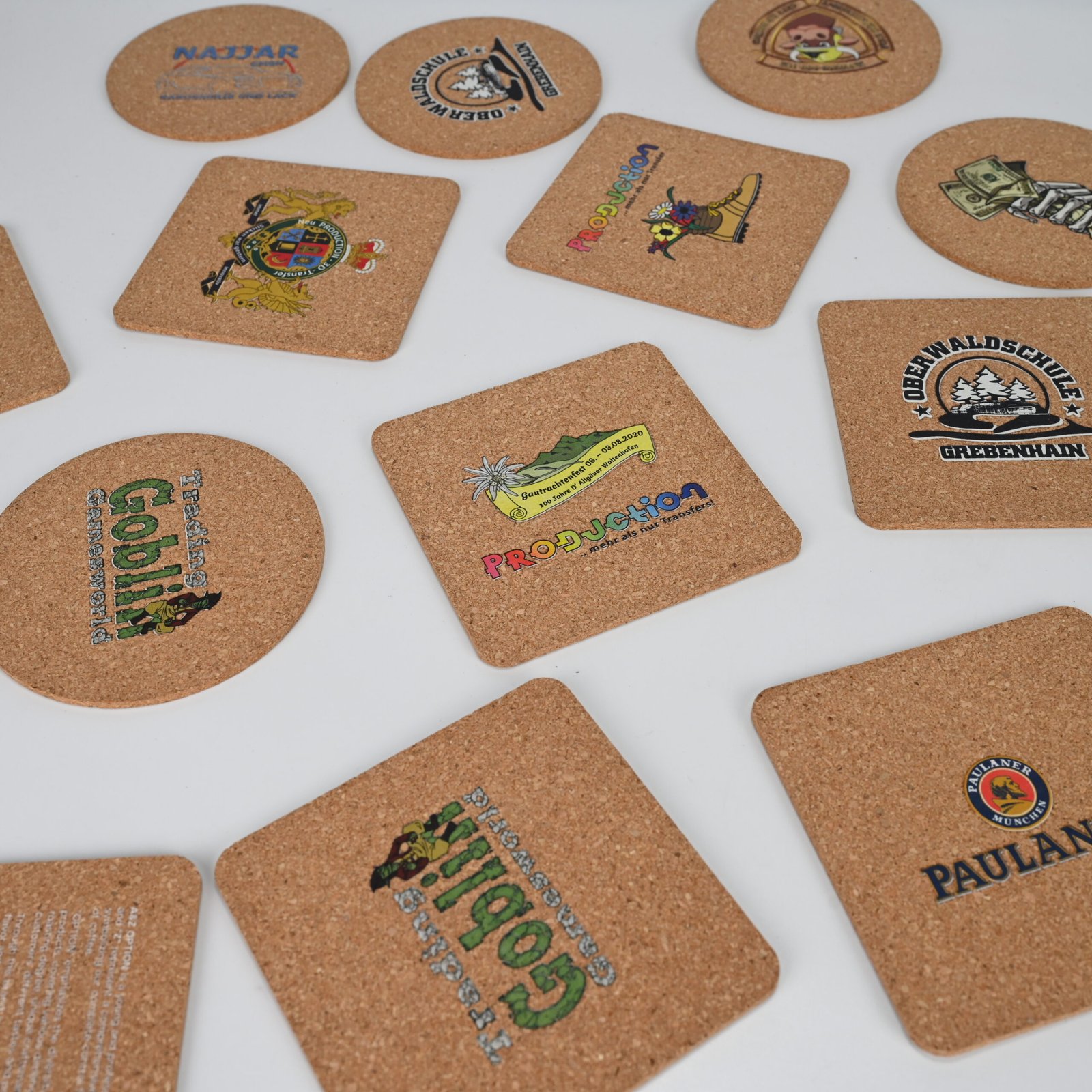 Wide array of custom cork coasters in round and square shapes with various client brand designs