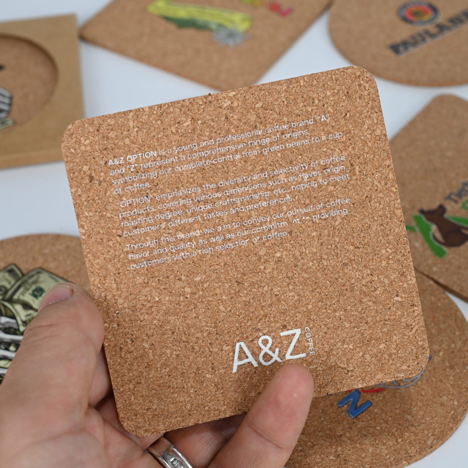 Square cork coasters showing different client logos and full-color custom prints